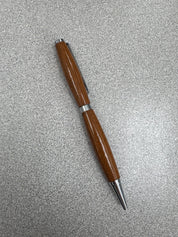 Wooden pen with silver accents on a gray surface