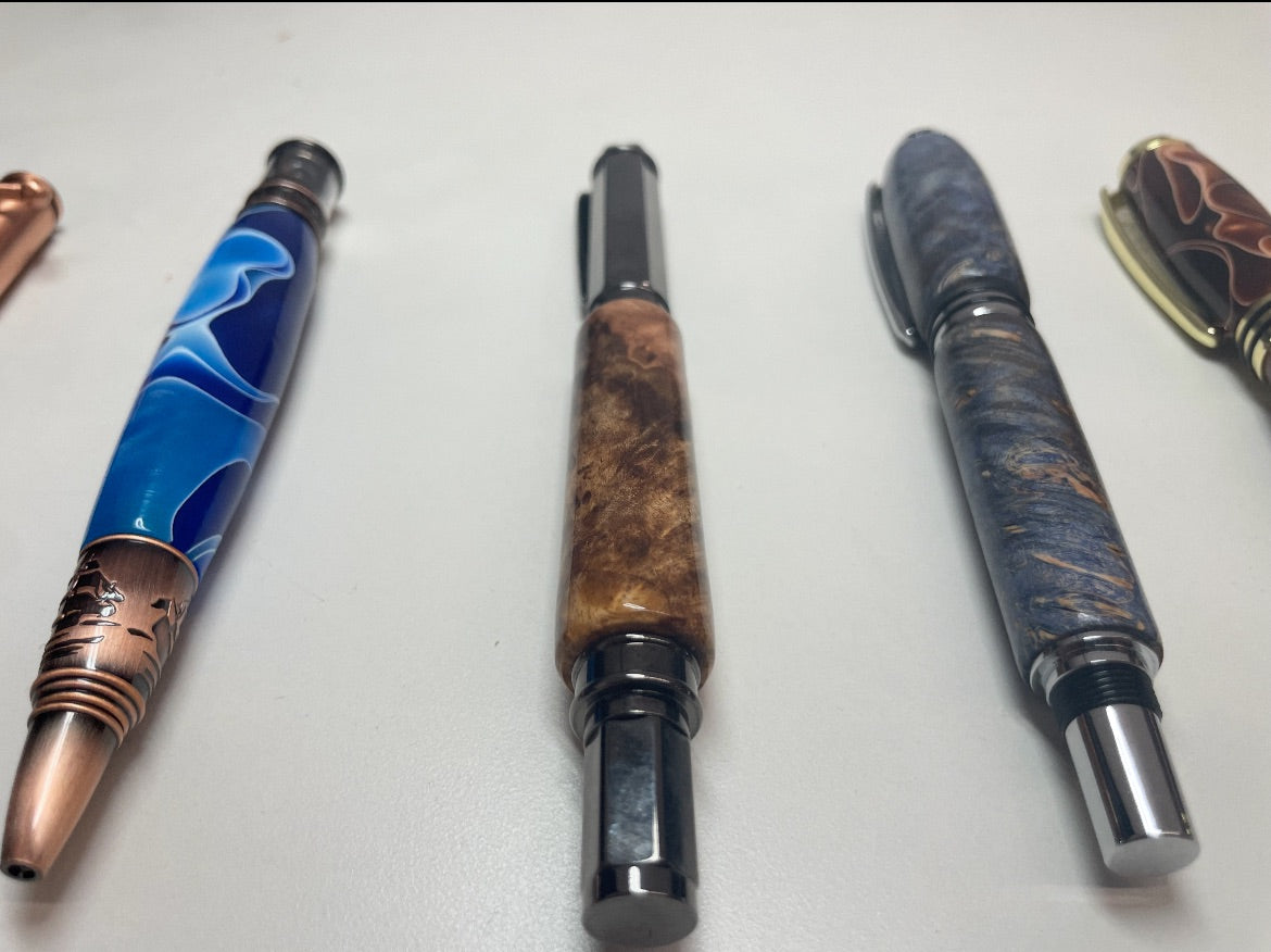 Three intricately designed pens on a white surface